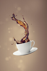 Coffee cup with splash of coffee isolated on blurred background
