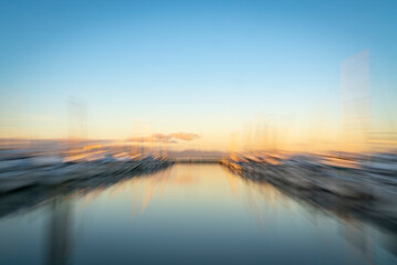 Abstract impressionist style Tauranga Marina boats and piers reflected in calm water at sunrise