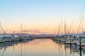 Obraz na płótnie Canvas Tauranga Marina boats and piers reflected in calm water at sunrise