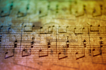 Close-up of music sheet in candle fire lights.