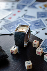 Picture of a square watch without numbers, with a leather strap. In a poker based background.