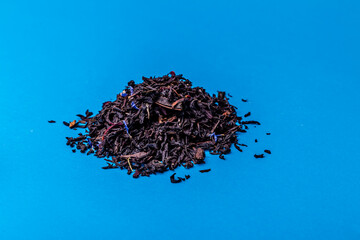 Heap of black tea on a blue background.