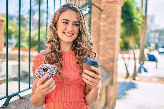 Young blonde girl smiling happy having breakfast at the city.
