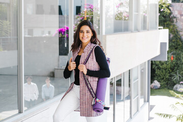 young mexican business woman or student practicing breathing yoga exercises at workplace, office meditation holding a cellphone on Mexico city or latin america