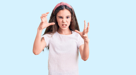 Fototapeta na wymiar Cute hispanic child girl wearing casual white tshirt shouting frustrated with rage, hands trying to strangle, yelling mad