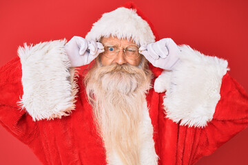 Old senior man with grey hair and long beard wearing santa claus costume holding glasses skeptic and nervous, frowning upset because of problem. negative person.