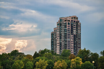 Fototapeta premium Apartment Building Skyline Above Park With Trees