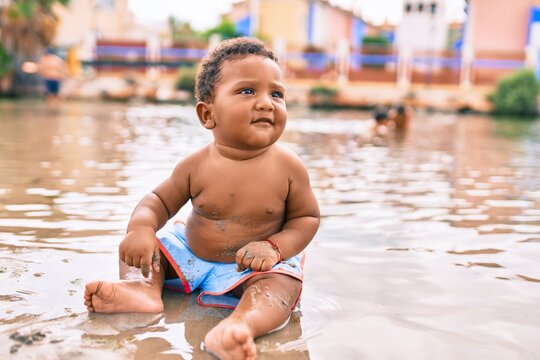 Adorable african american toddler sitting at the beach.