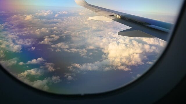 Airplane passenger window view flying through the clouds.