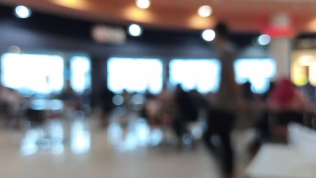 blurred bokeh defocused background of food court restaurant cafe inside Interior of a mall with people walking by
