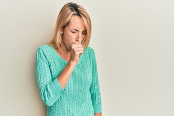 Beautiful blonde woman wearing casual winter sweater feeling unwell and coughing as symptom for cold or bronchitis. health care concept.