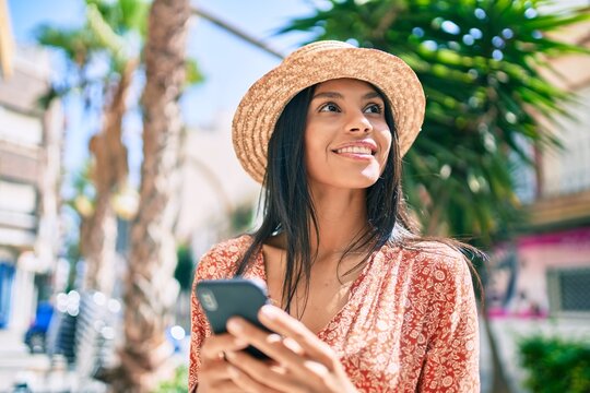 Young african american tourist woman on vacation smiling happy using smartphone at the city.