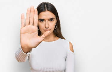 Young hispanic woman wearing casual clothes doing stop sing with palm of the hand. warning...