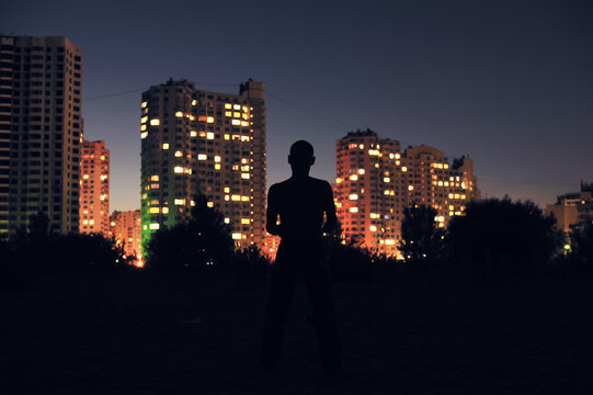 Silhouette of a man on a night city background.