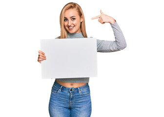 Fototapeta premium Beautiful caucasian woman holding blank empty banner pointing finger to one self smiling happy and proud