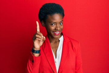 Young african american girl wearing business clothes showing and pointing up with finger number one while smiling confident and happy.