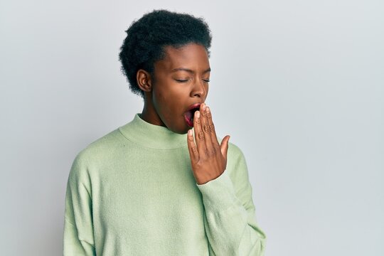 Young african american girl wearing casual clothes bored yawning tired covering mouth with hand. restless and sleepiness.