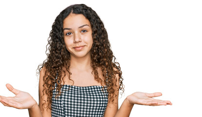 Teenager hispanic girl wearing casual clothes clueless and confused expression with arms and hands raised. doubt concept.