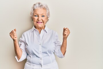 Senior grey-haired woman wearing casual clothes celebrating surprised and amazed for success with arms raised and eyes closed