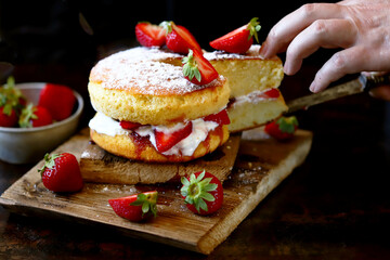 Soft focus. Victoria sponge cake. The famous dessert biscuit with strawberries.