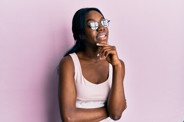 Young african american woman wearing casual clothes and glasses smiling looking confident at the...
