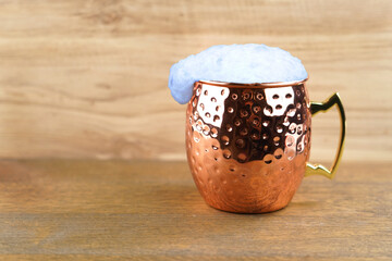Ayran - Traditional Turkish yoghurt drink with foam in a copper metal cup .