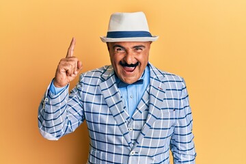 Mature middle east man with mustache wearing vintage and elegant fashion style pointing finger up with successful idea. exited and happy. number one.