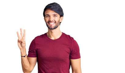 Handsome hispanic man wearing casual clothes showing and pointing up with fingers number three while smiling confident and happy.