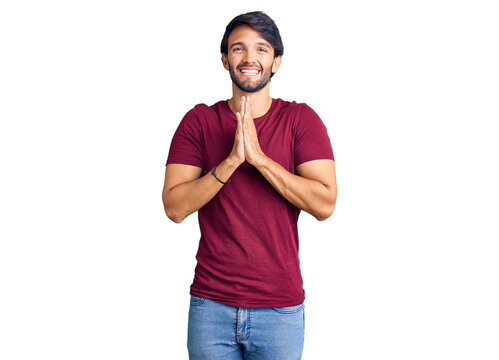 Handsome hispanic man wearing casual clothes praying with hands together asking for forgiveness smiling confident.