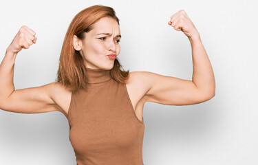 Young caucasian woman wearing casual clothes showing arms muscles smiling proud. fitness concept.