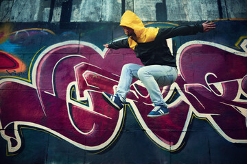 Close-up of a young brunette man in a jacket near a wall in an underpass.