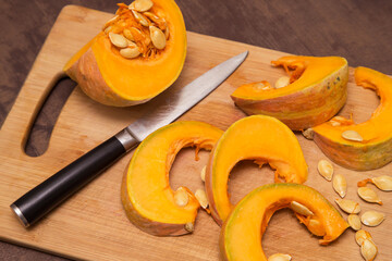 Cutting pumpkin vegetable on wooden board. Cooking healthy vegetarian food at home