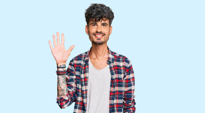 Young hispanic man wearing casual clothes showing and pointing up with fingers number five while smiling confident and happy.