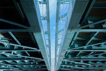 Pair of bridges with the sky peaking through the middle.