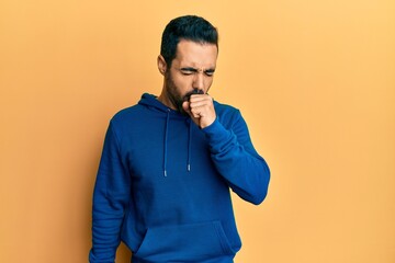 Young hispanic man wearing casual clothes feeling unwell and coughing as symptom for cold or bronchitis. health care concept.