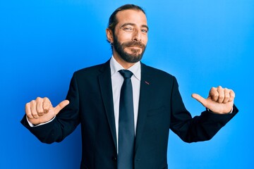 Attractive man with long hair and beard wearing business suit and tie looking confident with smile on face, pointing oneself with fingers proud and happy.