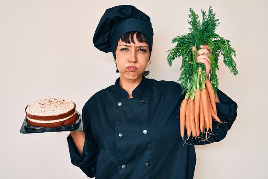 Beautiful brunettte woman chef cooking carrot cake puffing cheeks with funny face. mouth inflated with air, catching air.
