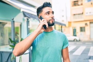 Young arab man with serious expression talking on the smartphone at the city.