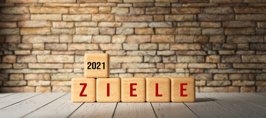 Fototapeta na wymiar wooden cubes with the German message for GOALS 2021 on wooden surface in front of a brick wall