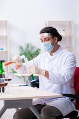 Male chemist examining wine samples at lab