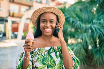 Young african american tourist woman on vacation Talking on the smartphone and eating ice cream at...