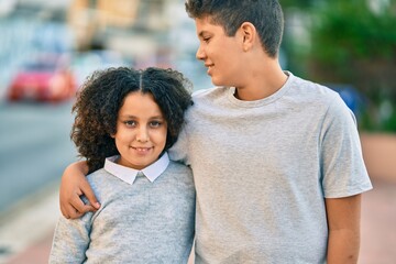 Fototapeta premium Adorable latin brother and sister hugging at the park.