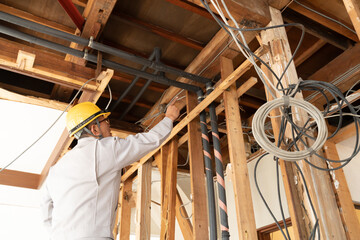 住宅リフォーム　スケルトンリフォーム　解体現場を調査するビジネスマン