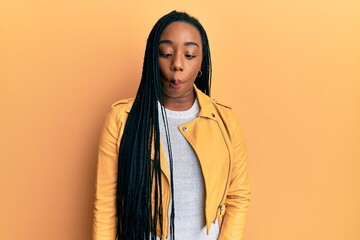 Young african american woman wearing casual jacket making fish face with lips, crazy and comical gesture. funny expression.