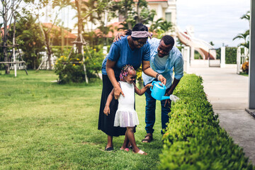 Fototapeta premium Portrait of enjoy happy love black family african american father and mother with little african girl child smiling and play having fun moments good time in summer park at home