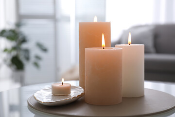 Burning candles on table indoors. Interior elements