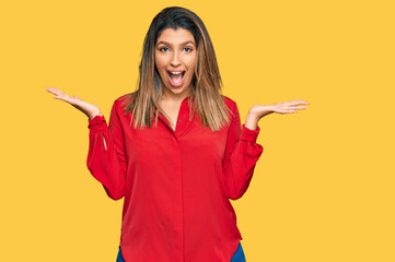 Beautiful brunette woman wearing casual clothes celebrating victory with happy smile and winner expression with raised hands