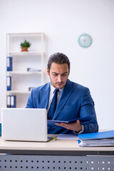 Young male employee working at workplace