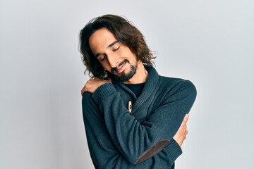 Young hispanic man wearing casual clothes hugging oneself happy and positive, smiling confident. self love and self care