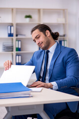 Young male employee working at workplace